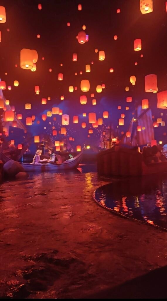 Floating glowing sky lanterns reflecting on the water at Rapunzel's Lantern Festival in Tokyo DisneySea Fantasy Springs