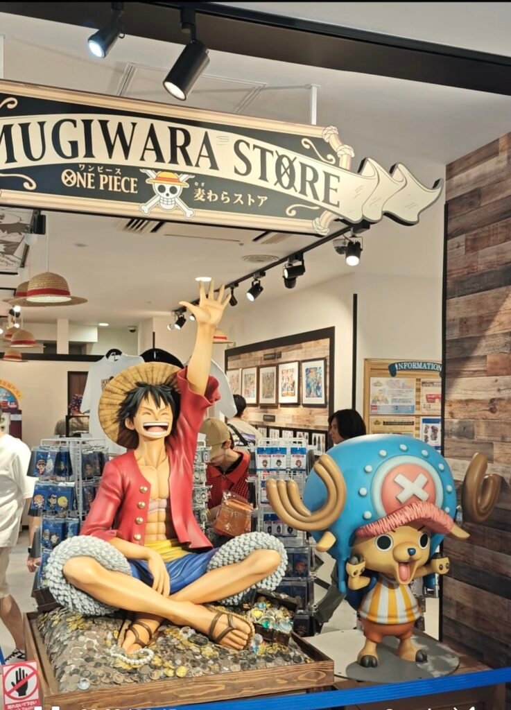 Life-sized Monkey D. Luffy and Tony Tony Chopper statues sitting on a treasure chest at the Mugiwara Store.