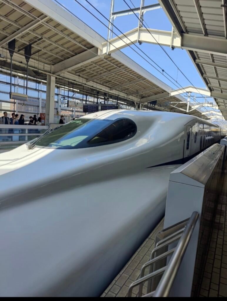 Sleek white Shinkansen N700 series bullet train parked at the station platform in Japan.