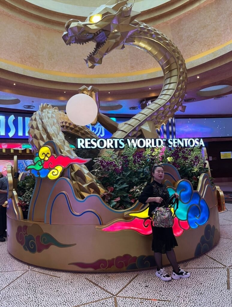 Golden dragon sculpture installation glowing inside Resorts World Sentosa in Singapore.