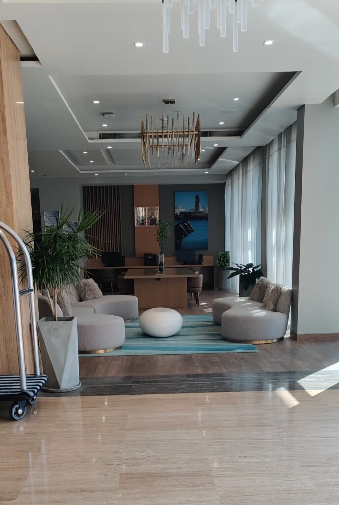 A clean, modern hotel lobby and reception area featuring stylish seating and polished tile flooring in Muscat, Oman. HOTEL - CITADINES AL GUBRAH